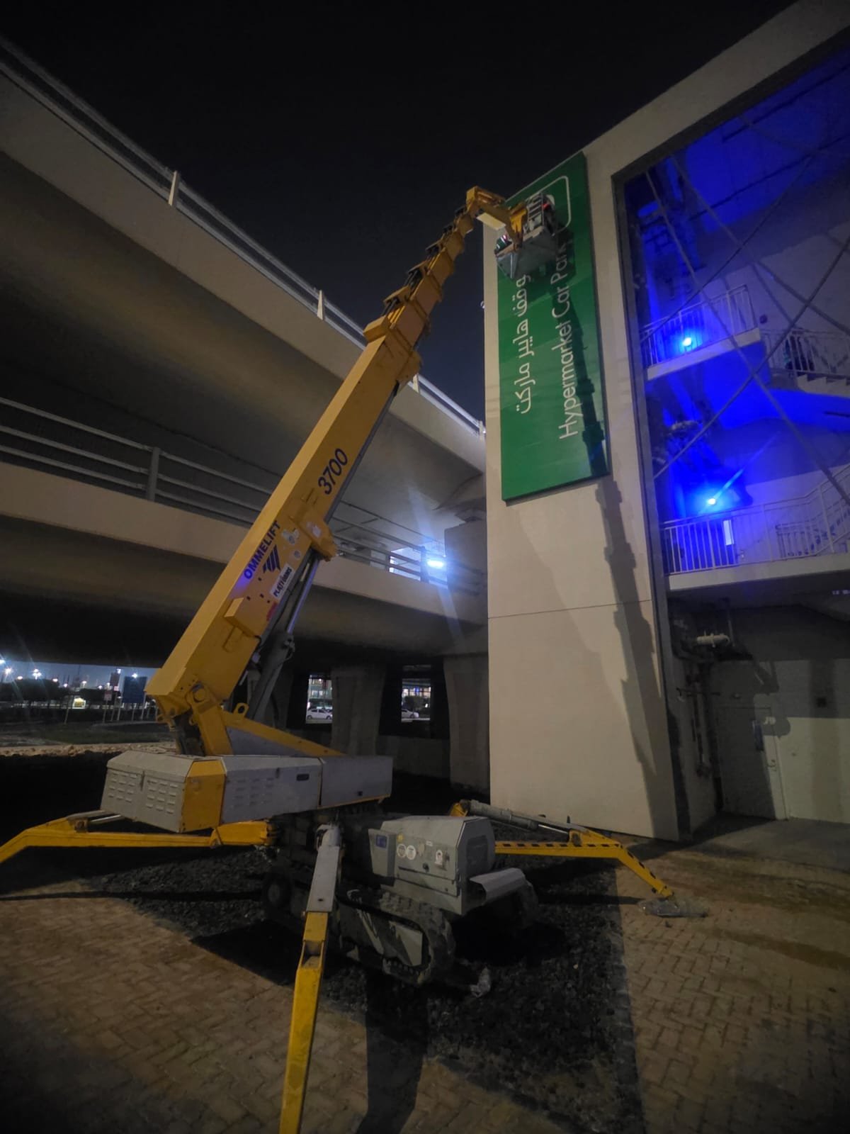 Spider lift lifting material through a building opening on a UAE construction site