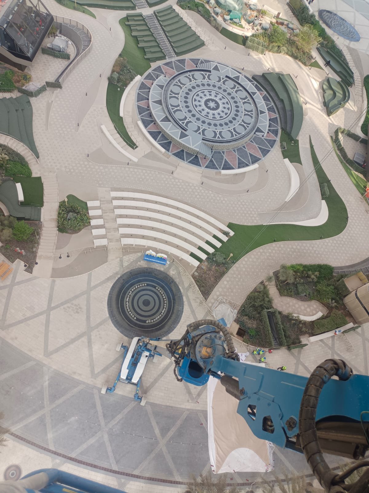 View from a fully extended boom lift basket over a landscaped plaza