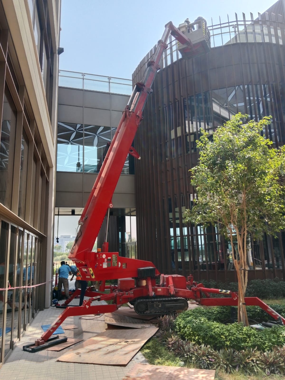 Spider lift working on the facade of a modern glass-clad building